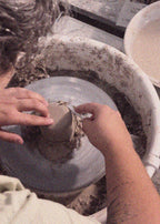 Girl doing the trimming of a pot in a Wheel Throwing Pottery Workshop in Setúbal near Lisbon