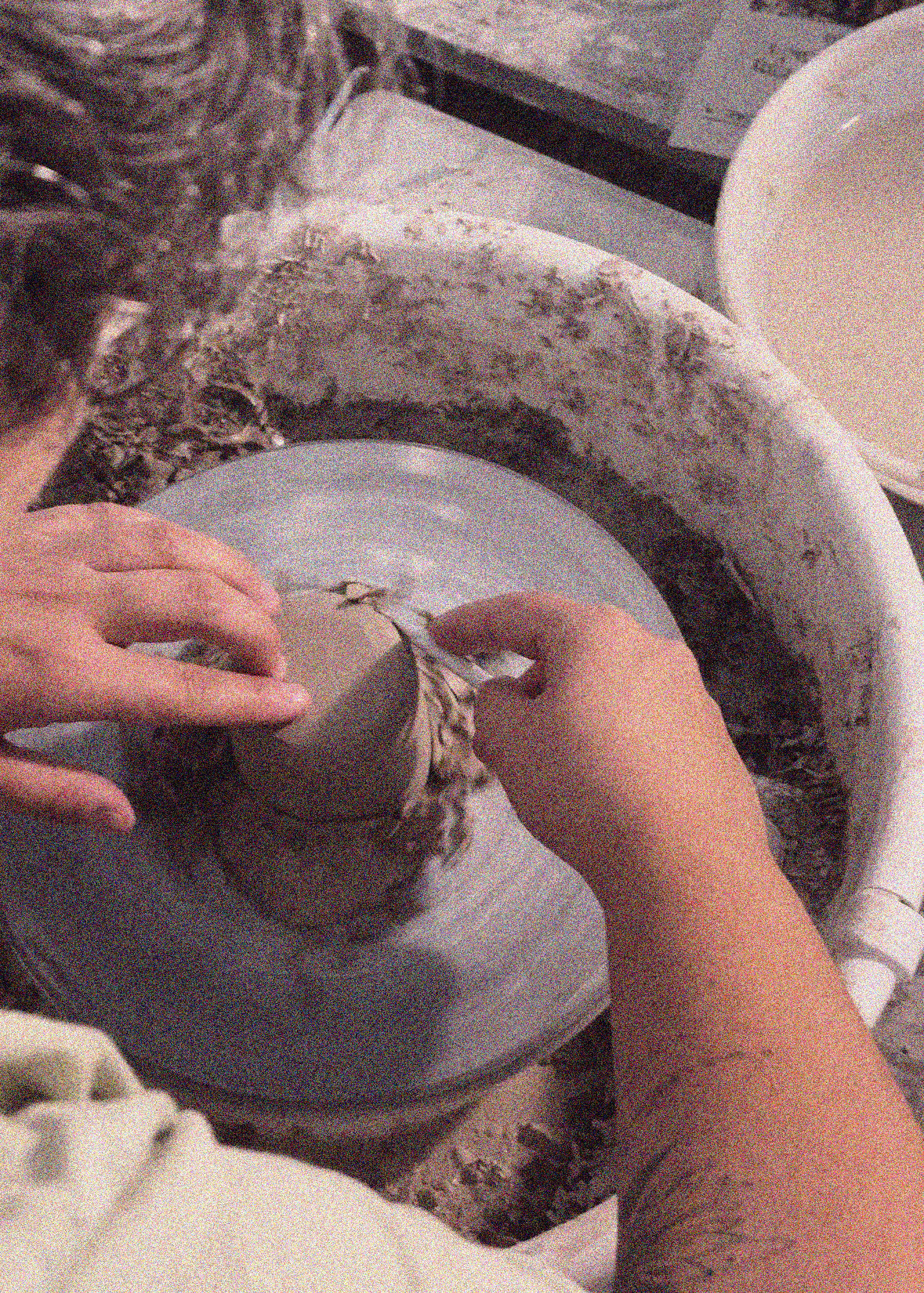 Girl doing the trimming of a pot in a Wheel Throwing Pottery Workshop in Setúbal near Lisbon